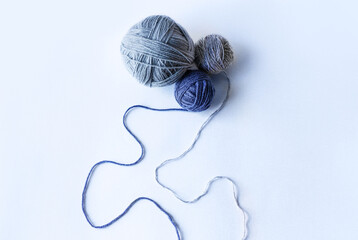 Three blue knitted wool on a blue background for knitting warm clothes, hobbies