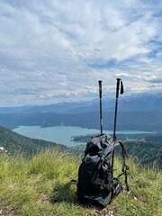 Vertical shot of alpine lake Walchensee with a backpack and trekking poles in the foreground