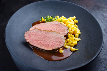 Tafelspitz Braten Scheiben vom Kalb mit schwäbische Spärtle serviert mit Dunkelbier Sauce als close-up in einem Design Teller 