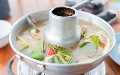 tom yum pork hot pot, Thai food, Asian food, bowl with fire below