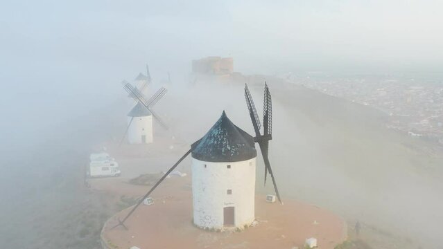 Typical old white Spanish windmills (Molinos appearing in Don Quijote) surrounded by a dry landscape in Consuegra, Toledo. Castilla la Mancha, Spain