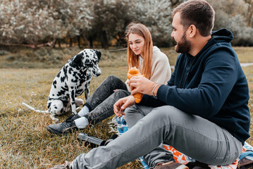 Happy time of a young couple relaxing in nature with a Dalmatian dog - Powered by Adobe