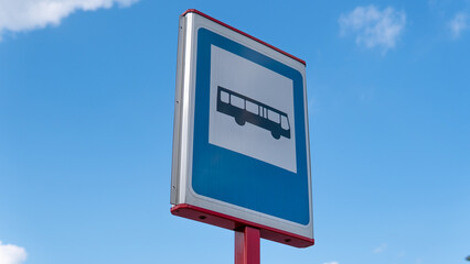  Bus stop sign against blue sky 