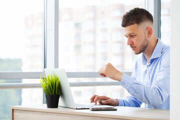 Young business man working at home with laptop and papers on desk