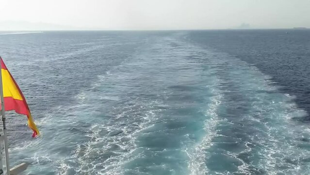 Wake behind the ship on the crossing between Ceuta and Algeciras in the Strait of Gibraltar, Spanish flag