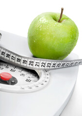 A Green Apple and a Measuring Tape on a Weight Scale