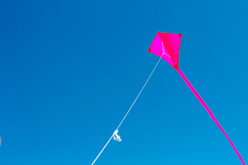 Pink kite flying with blue sky in Germany.