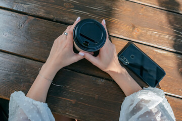 The girl is sitting in a summer cafe.