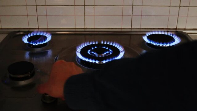 Gas cooker with burning flames of gas. Domestic kitchen with blue flames burning