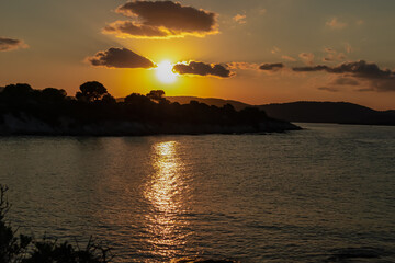 Panoramic view of coastline during sunset near Karydi beach, Vourvourou, Sithonia, Chalkidiki (Halkidiki), Greece, Europe. Vacation summer at Aegean Mediterranean Sea. Romantic atmosphere. Seascape
