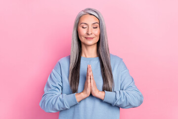 Photo of cute dreamy lady pensioner dressed blue pullover enjoying yoga isolated pink color background