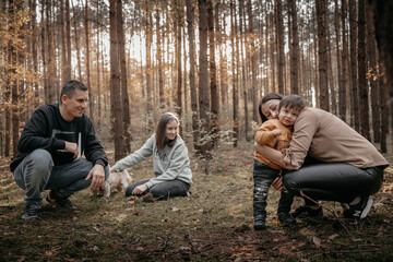 joyful family in the woods during the autumn walk