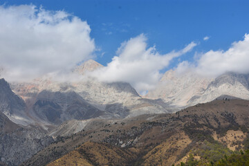
panoramic view of the mountain range in the clouds with blue sky on the background in Arslanbob in...