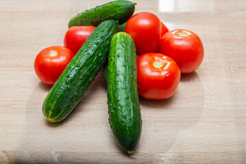 Fresh vegetables on a wooden table. Tomatoes, cucumbers, onions