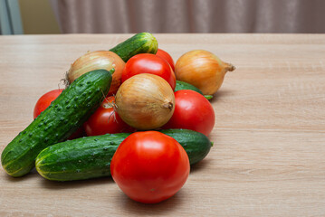 Fresh vegetables on a wooden table. Tomatoes, cucumbers, onions
