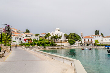 Beautiful View of Spetses Town with Traditional Neoclassic Buildings and White Cathedral Church by the Sea. Picturesque Bay in Saronic Gulf, Spetses Island, Greece