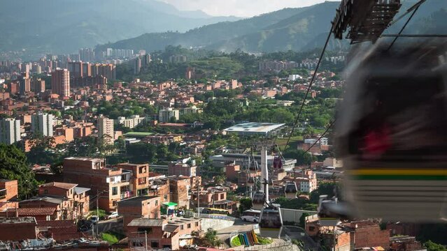 Time lapse view of modern MetroCable public transit system showing cable cars traveling over the city of Medellin, Antioquia Department, Colombia.	