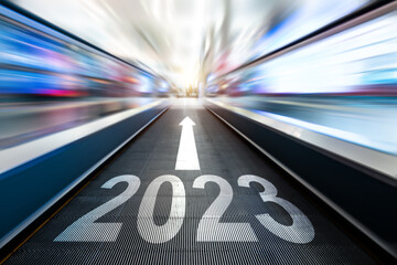 Moving escalator walkway with new year number 2023 and arrow sign in the airport