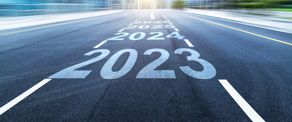Black asphalt road with new year numbers 2023, 2024 to 2026 with white dividing lines - obrazy, fototapety, plakaty