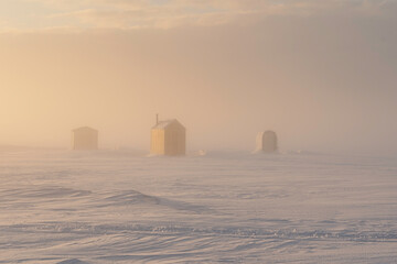Socked in with fog at the ice fishing on a frozen harbor in rural Prince Edward Island, Canada.
