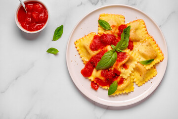 Delicious appetizing ravioli with tomato sauce and basil