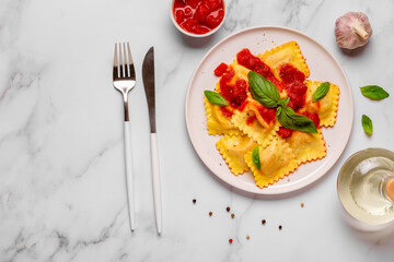 Delicious appetizing ravioli with tomato sauce and basil