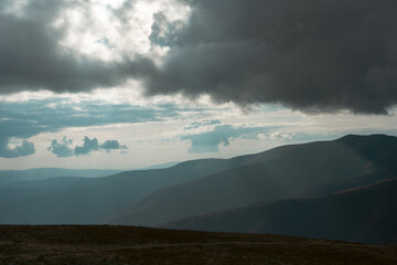 Beautiful view of the carpathian moun landscape with green meadows, trees, dark low clouds on the mountains in the background. travel destinations.