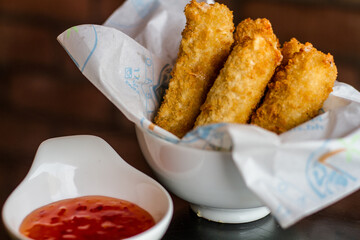 MOZZARELLA STICKS with chilli sauce served in a dish isolated on table side view