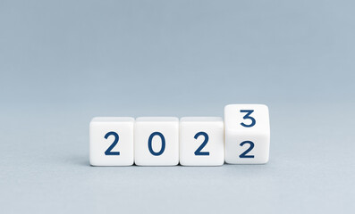 Change from 2022 to 2023 on cube blocks on blue background. New year is coming concept. Copy space