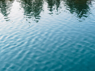 reflection of the treetops and ripples on the water of the lake