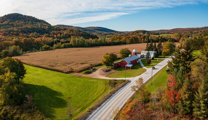 Aerial view of large red farm barn by the side of the road near Montgomery in Vermont during the autumn color season
