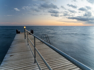 Naklejka premium Holzsteg in der Dämmerung und leuchtenden Pfosten
