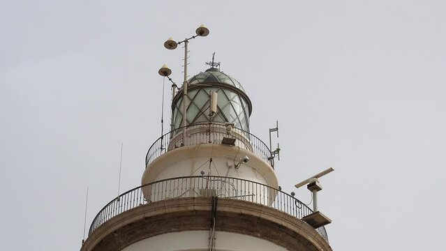 4k video of the lighthouse next to the commercial port of Malaga, Spain with the anenometer measuring the speed of the wind