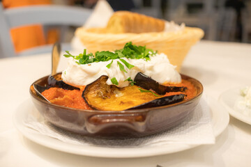 Eggplant in tomato sauce and feta cheese. Greek dish in a pan in Athens