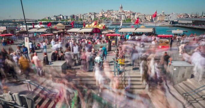 Timelapse motion: Eminonu square at sunny day, street of Istanbul, Turkey. Crowd of people going to the underground crossing. Sightseeing location, fishing boats, blured background
