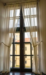 Obraz premium The window of an old house with light light curtains