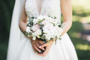 Bride holding big and beautiful wedding bouquet with flowers