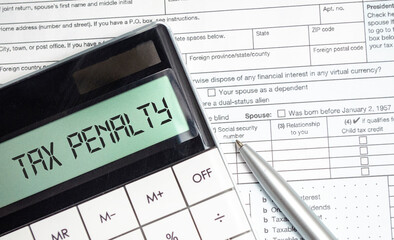 tax penalty words on calculator display with tax forms