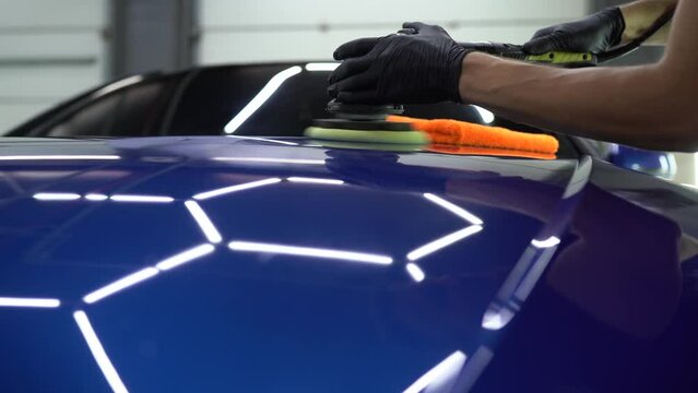 Hard wax car polishing with orbital polisher for remove scratches close-up. 4k video working process in detailing auto service.