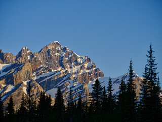 Glacial cut and snow covered rugged mountain peaks of the Canadian Rockies in early morning light