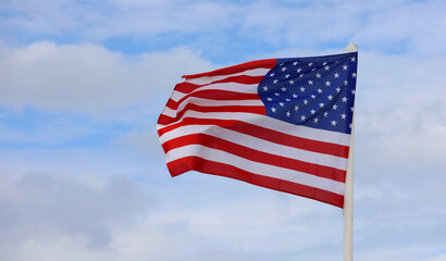 american flag with stars and red and white stripes on blue sky