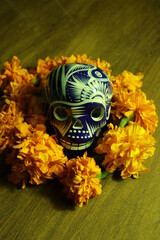 mexican skull decorated with smoke and yellow flowers for the day of the dead