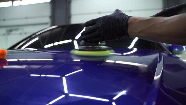 Abrasive paste car polishing with orbital polisher for remove scratches. 4k video. Worker of detailing auto service making final polishing for car.