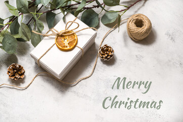 Merry christmas flatlay background. Present,twine,pine cones and eucalyptus on concrete background