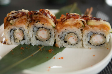 Sushi laid out in rice rolls, with fried prawns and red huove