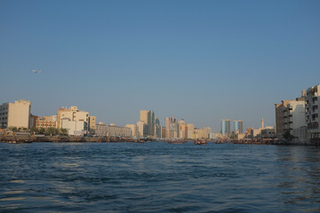 Old Dubai featuring abras, the creek, and the buildings of Deira and Al Fahidi Historical District. Summer day cityscape with blue sky.