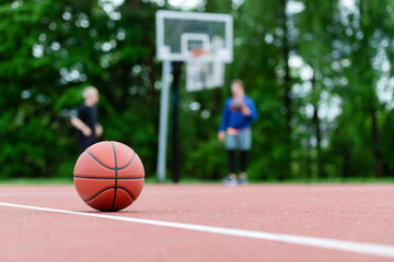 Orange basketball on brown court of gymnasium sport floor. Street basketball concept. Horizontal...