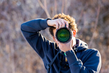 African American Male Photographer Holding Large camera to eye taking photo