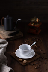 Empty cup of coffee and kettle beans at wood table. Homemade coffee on table