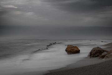 Playa con foto de larga exposicion con rocas